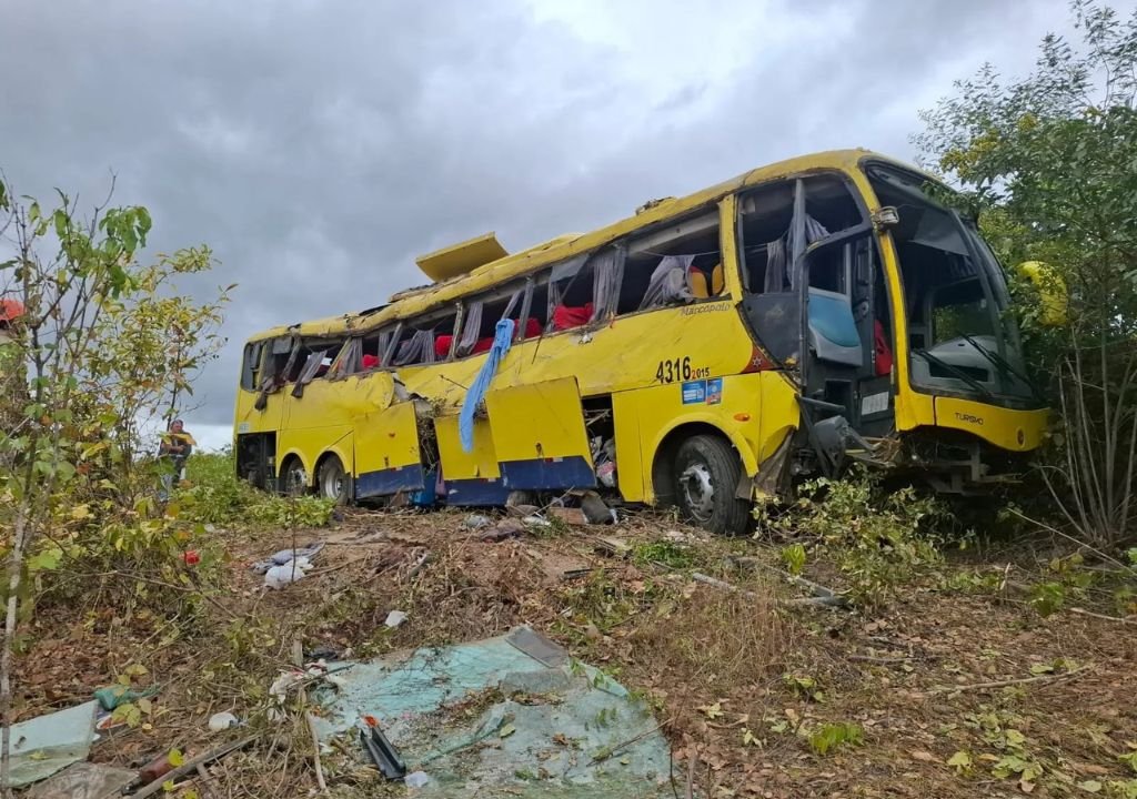 Ônibus de romeiros tombado na CE-456, em Canindé, durante acidente que deixou mortos e dezenas de feridos.